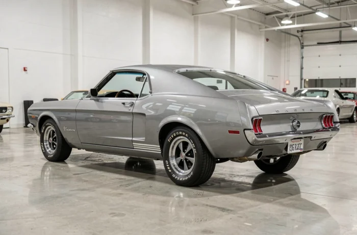 Ford Shelby GT500 Eleanor exposée dans un showroom automobile moderne, vue trois quarts arrière sur sol en béton poli